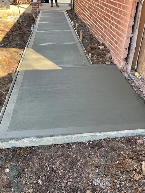 Concrete walkway beside a brick building
