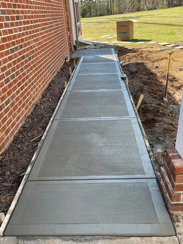 Concrete walkway along a brick house