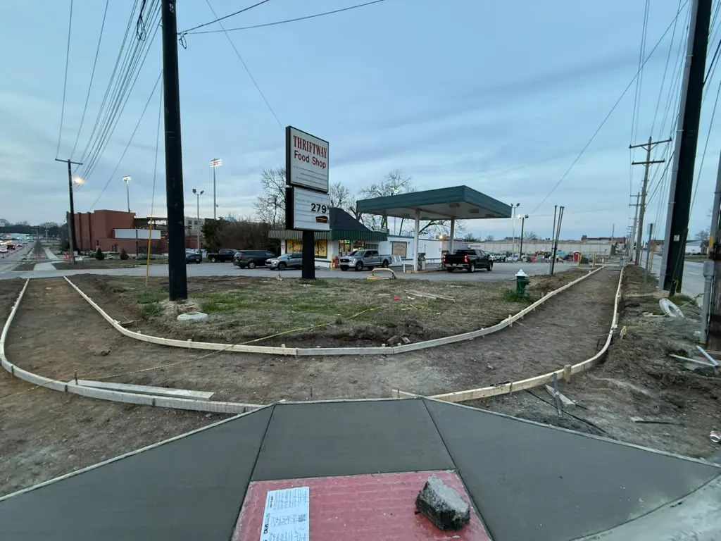 New ADA ramp with red detectable warning pad at a sidewalk corner