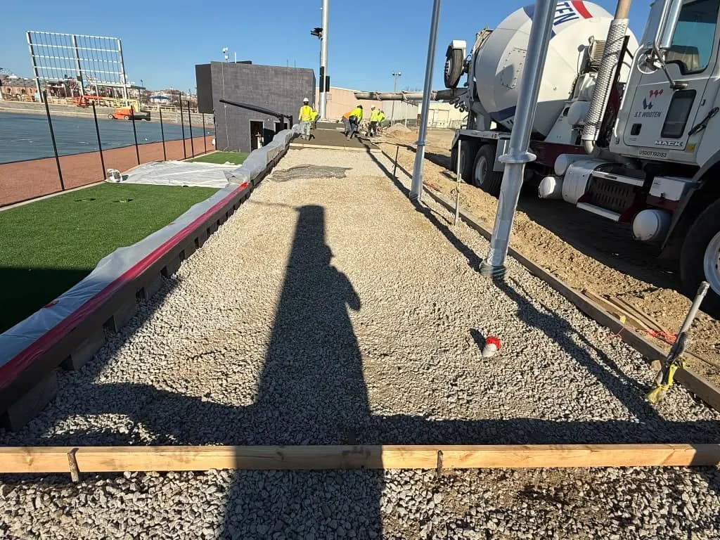 Gravel base with forms along a sports field