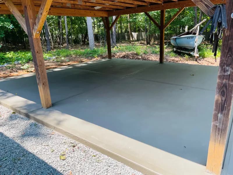Smooth concrete slab under a wooden carport