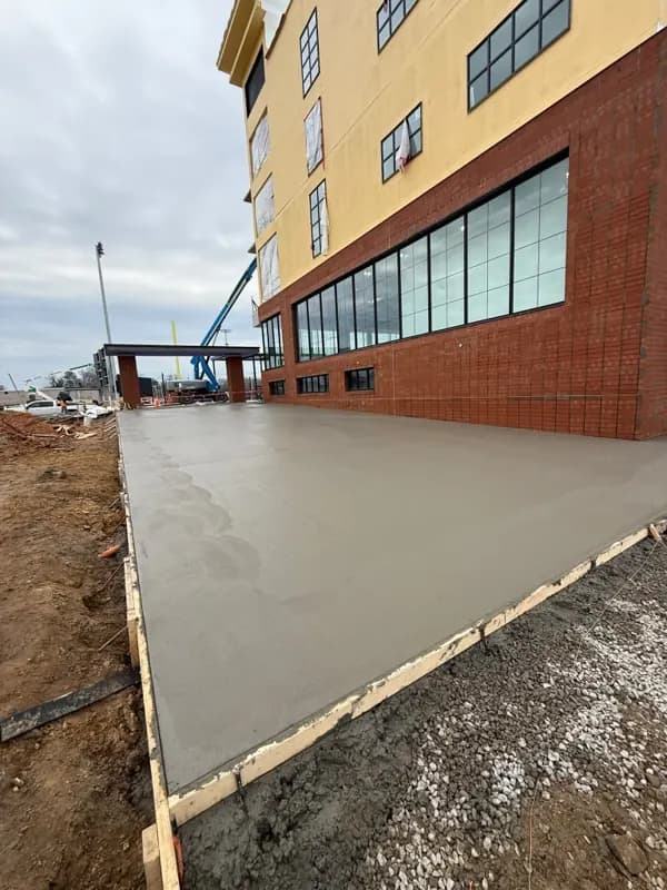 Large commercial concrete slab poured next to a multi-story building
