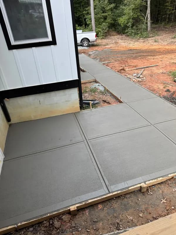 New concrete walkway running beside a home
