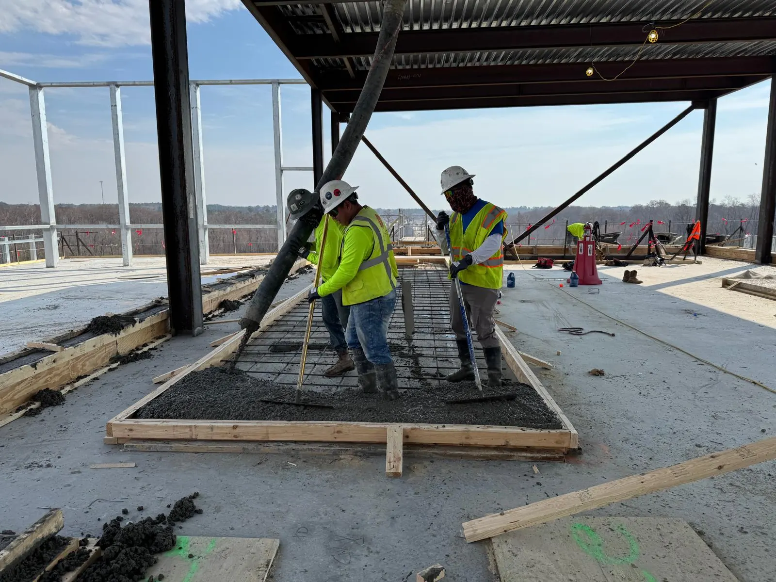 A&V crew placing concrete over rebar on a commercial rooftop
